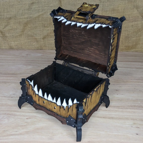 Open handcrafted wooden one-eyed mimic chest with latch detail, showing carved teeth inside the mouth.