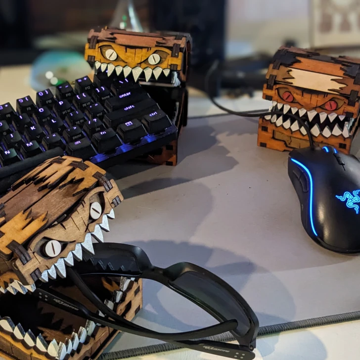 Handcrafted wooden fantasy storage boxes including mimic boxes, monster boxes, chests and book-style boxes, shown as playful mimics on a desk.