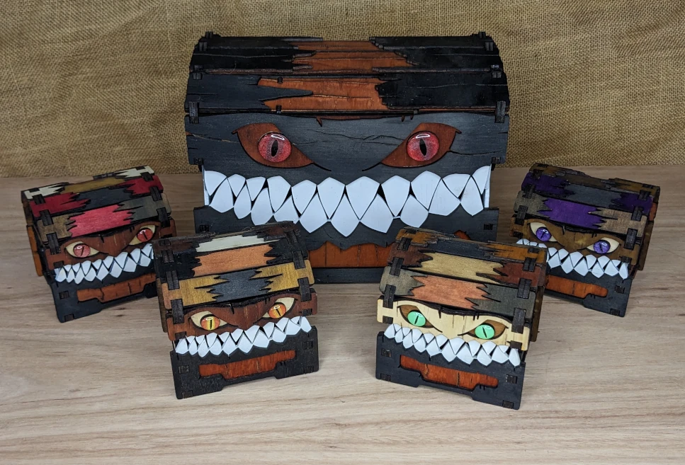Assortment of handcrafted wooden mimic chests in different colours, featuring varied eye designs to show custom options.