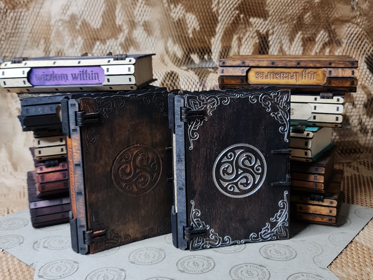 Dragon-inspired wooden book boxes featuring engraved dragon motifs and decorative filigree, shown in black and brown finishes.