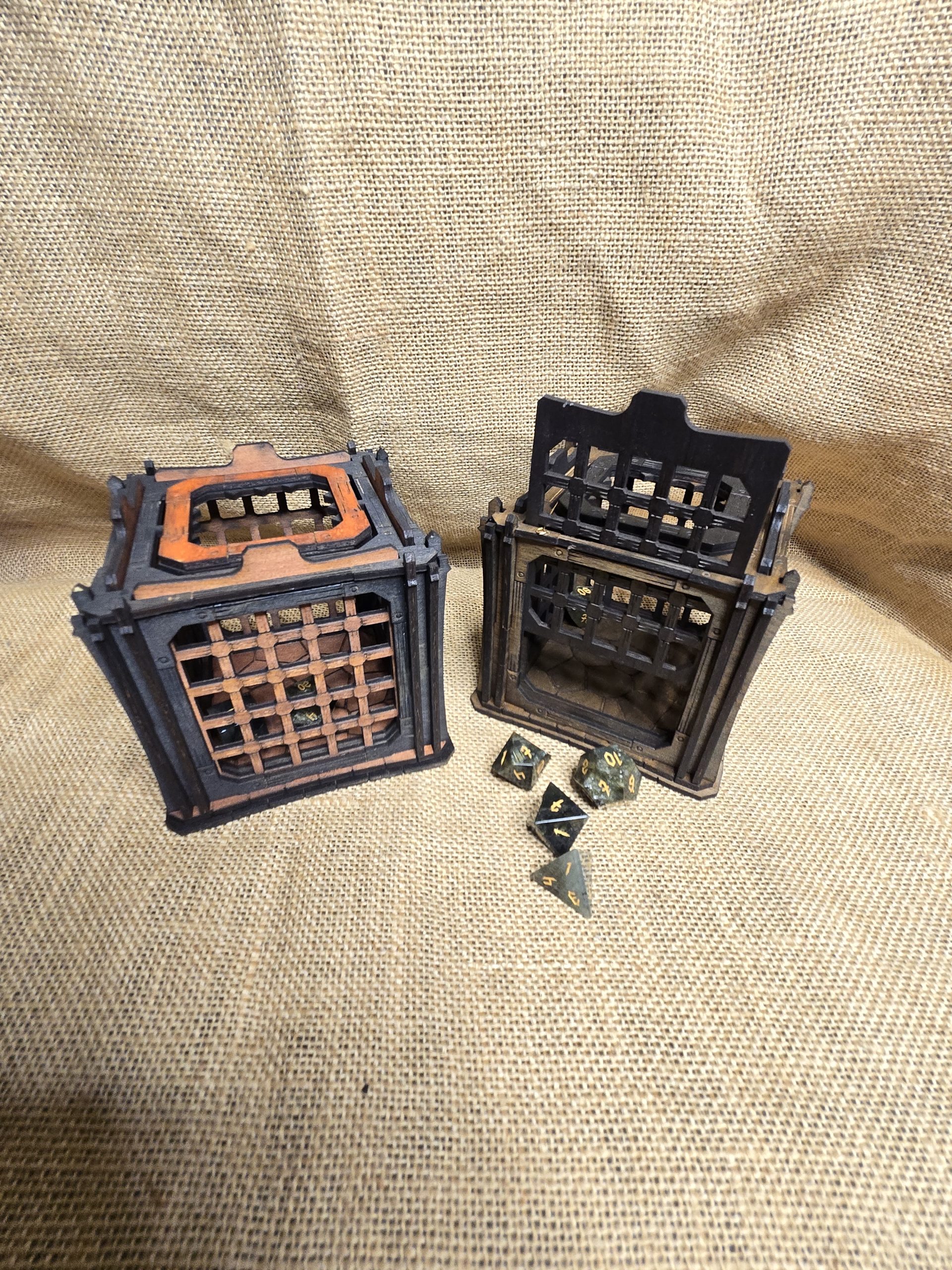 Wooden dice jail holding two dice, shown with a few dice escaping as a playful tabletop gaming accessory.