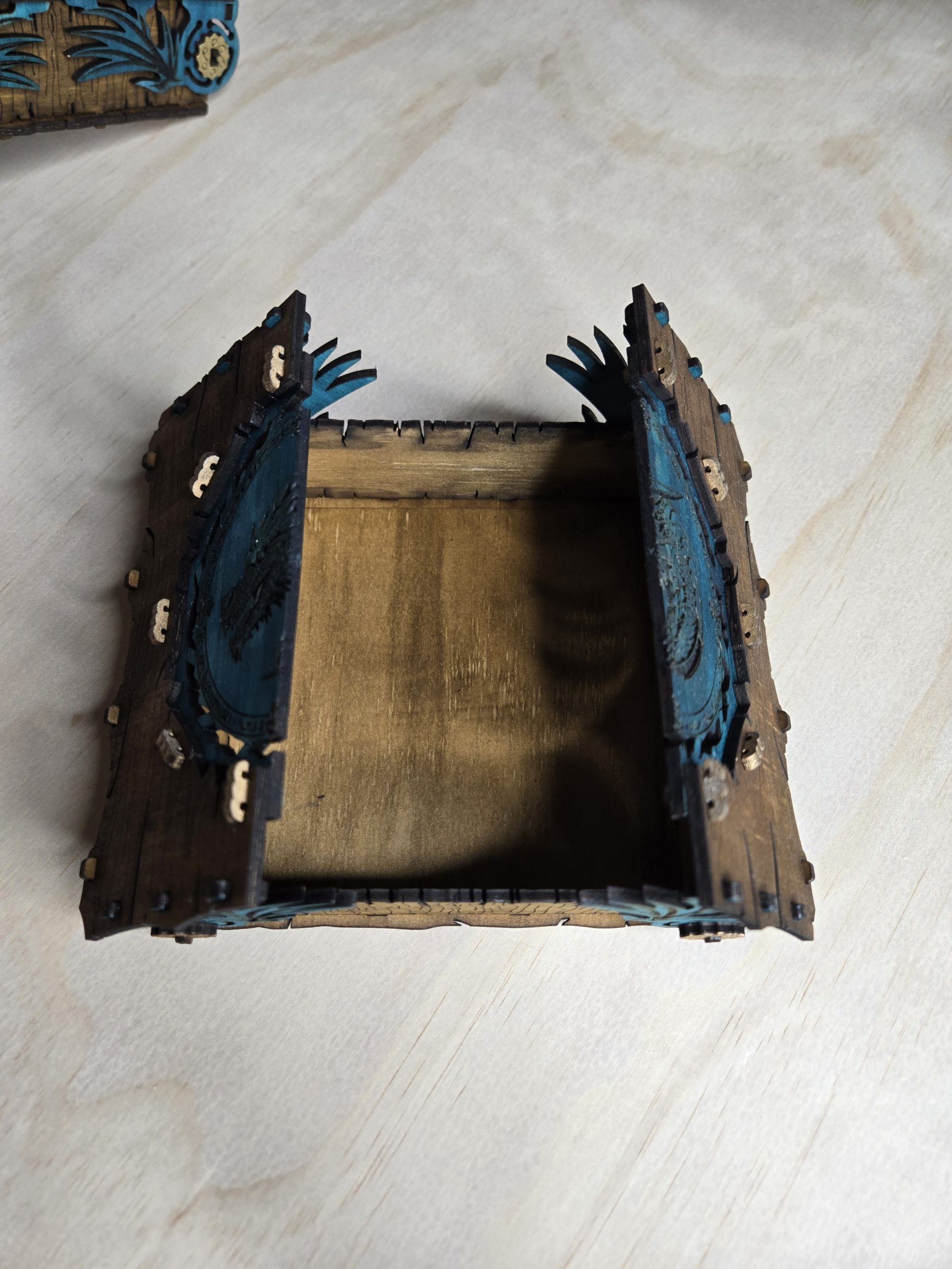 Handcrafted wooden two-door dragon box shown open, revealing internal storage compartments for dice, keepsakes or gaming accessories.