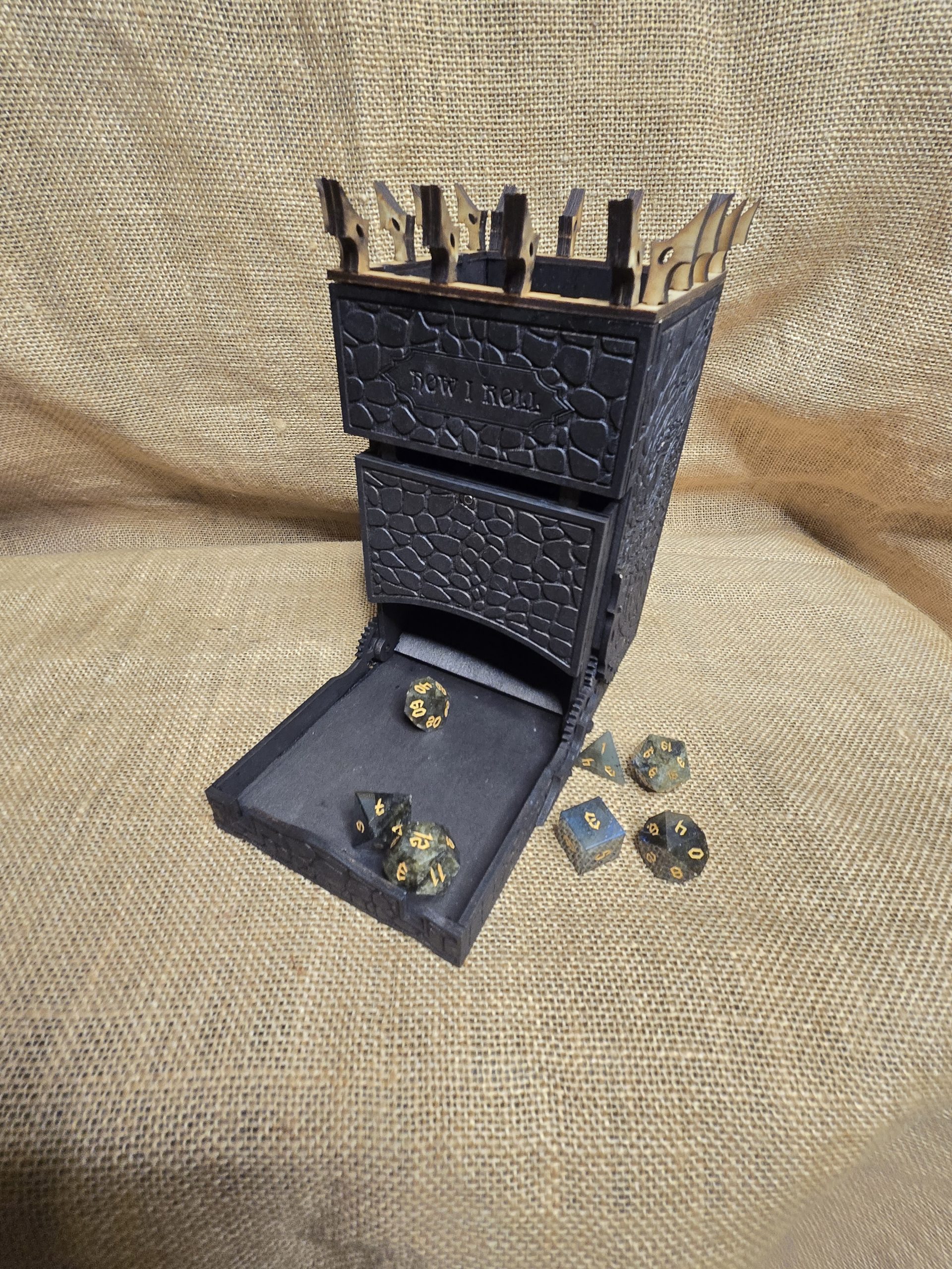 Black wooden dice tower with dragon scale engraving and hidden dragon eye detail, inspired by fantasy castles.