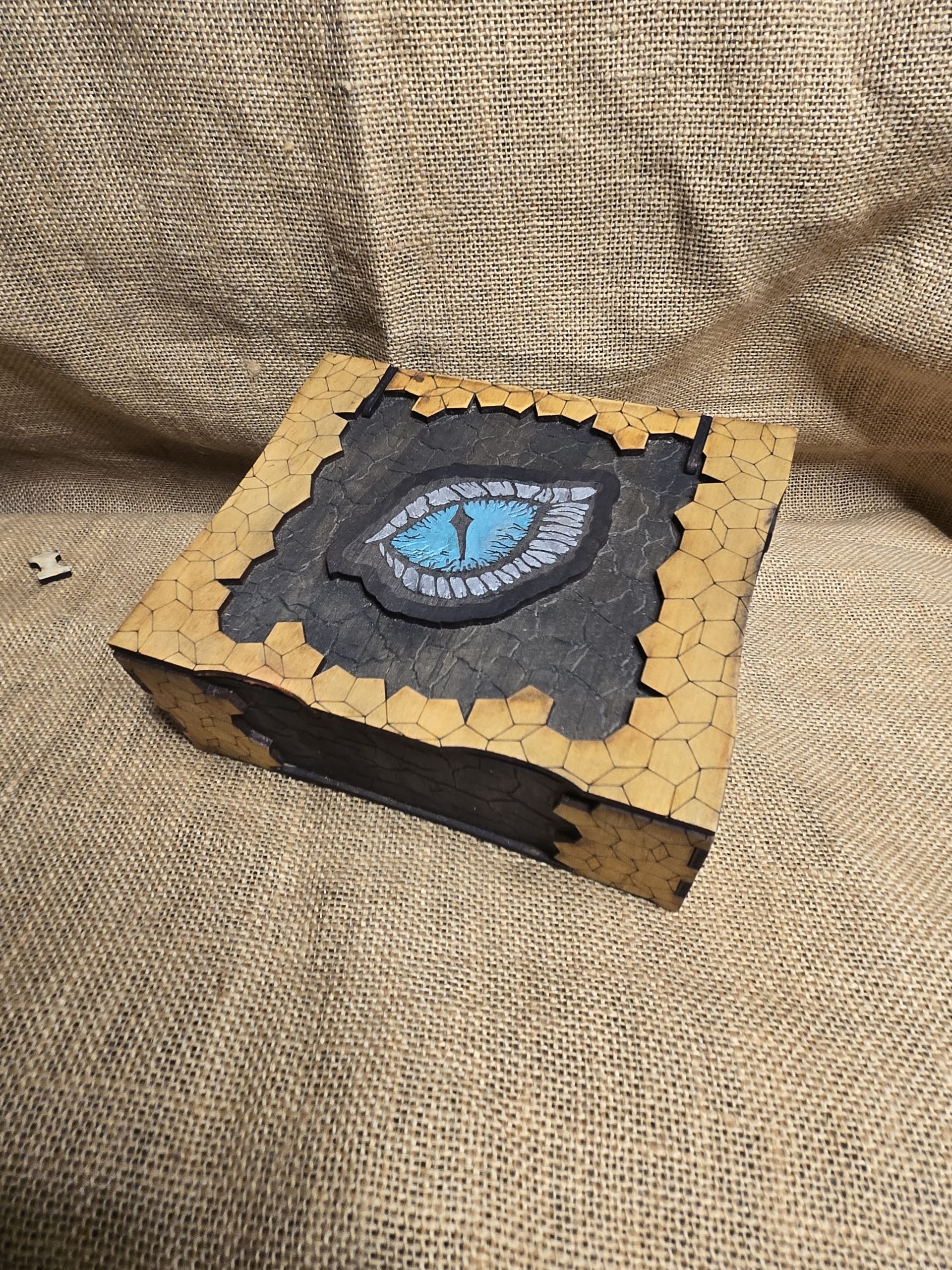 Wooden dragon eye box featuring engraved dragon scales and contrasting details, designed as a fantasy storage box for small items.