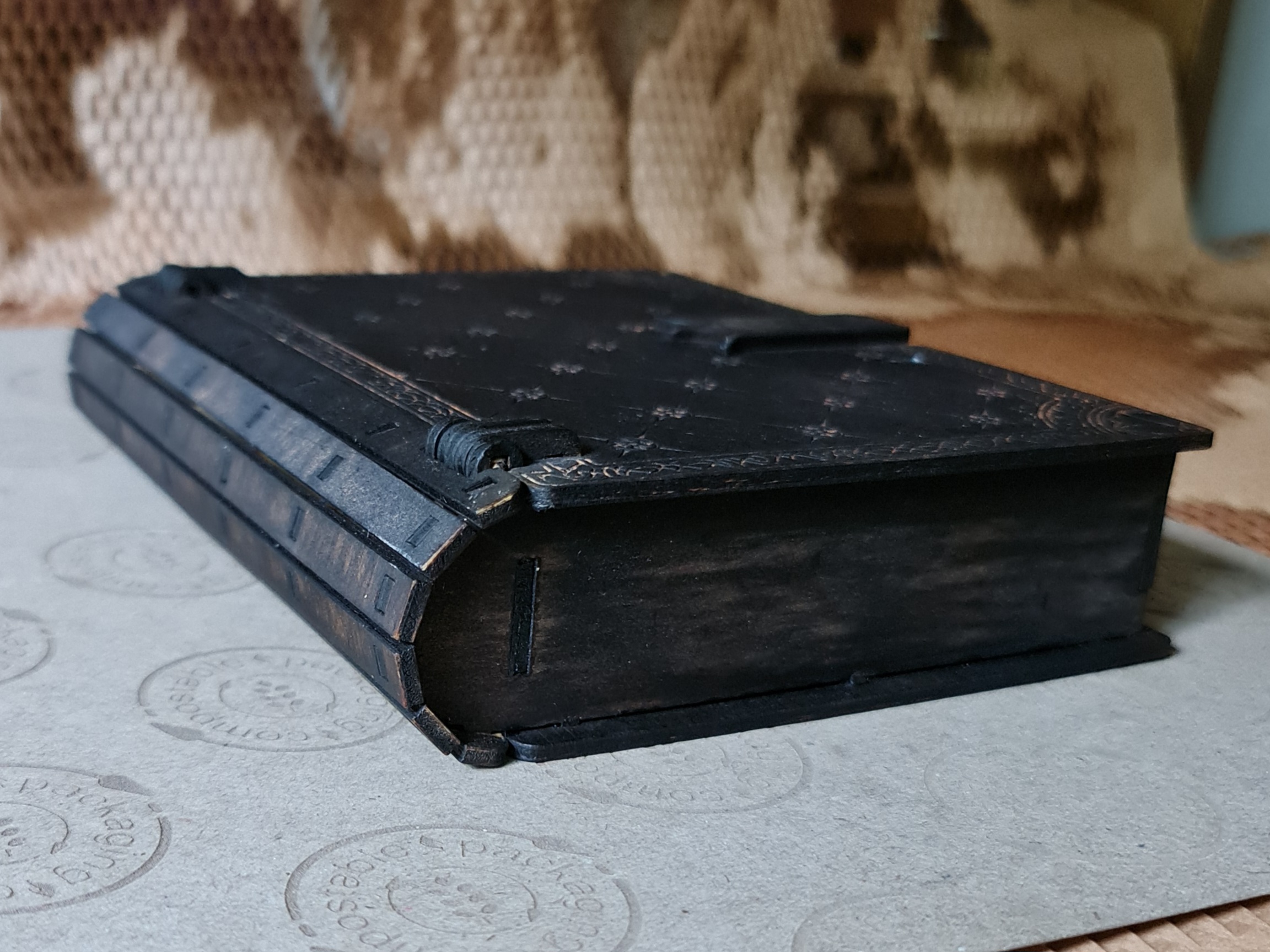 Antique-style black engraved wooden book box with silver detailing, shown laid flat to display spine and finish.