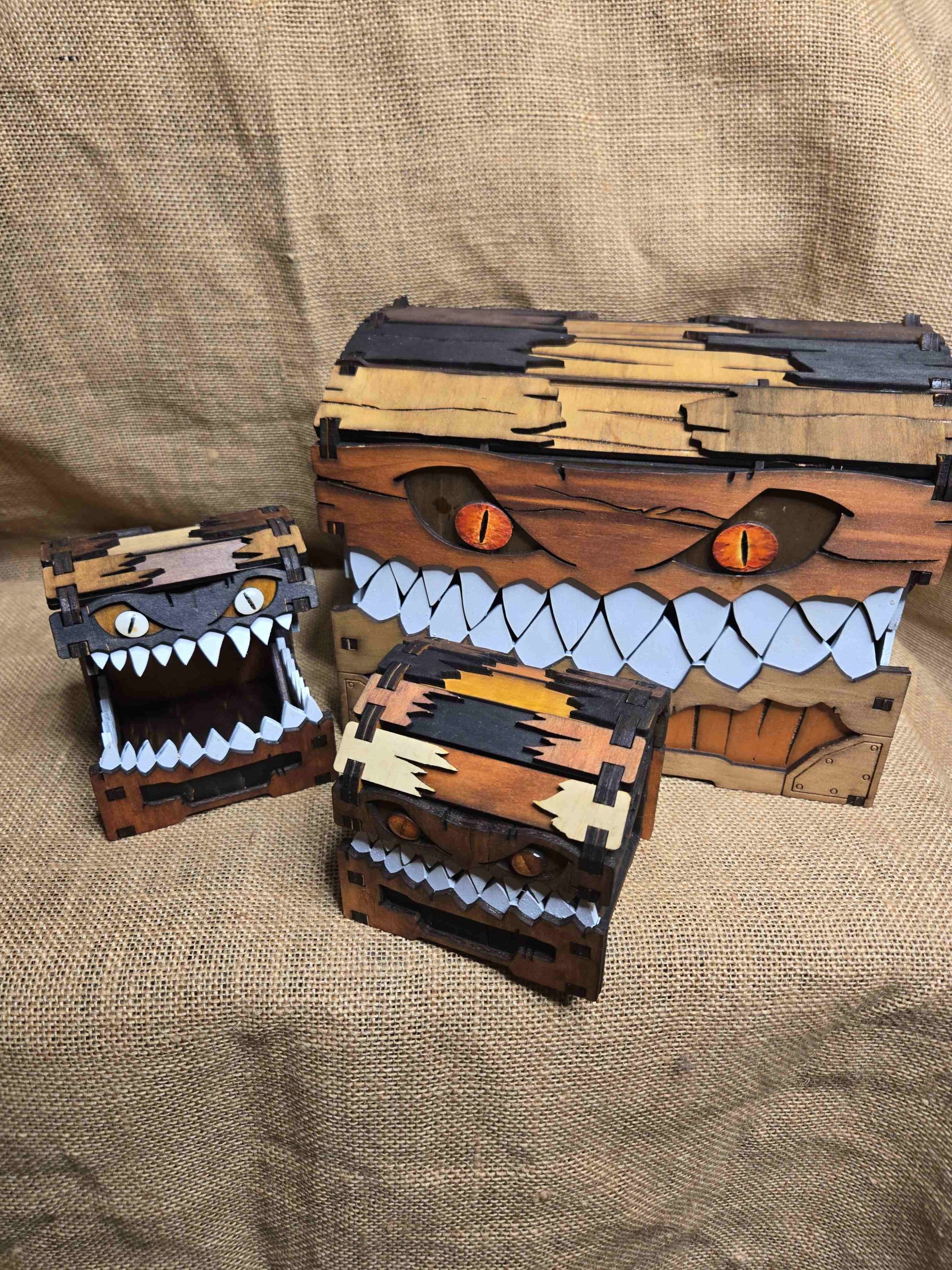 Handcrafted wooden mimic chests in multiple sizes, including a large mimic chest and two smaller chests, with one mimic shown with its mouth open.