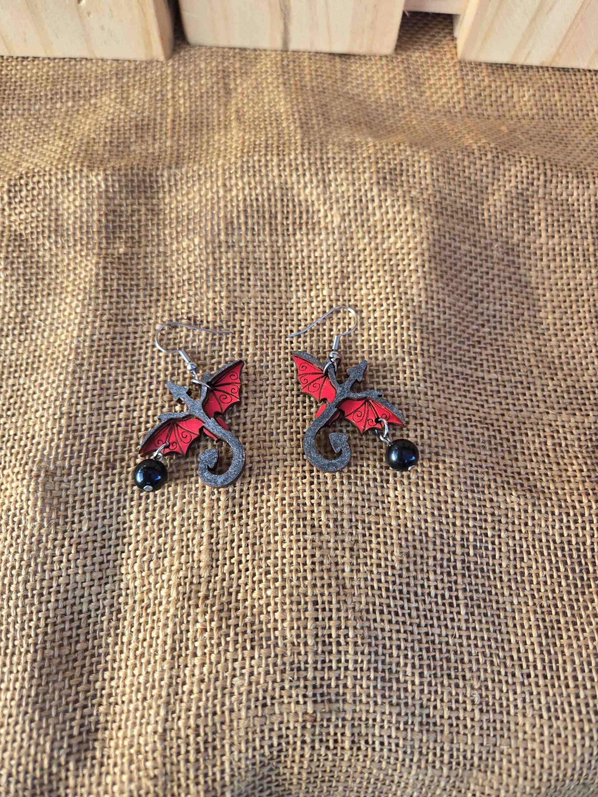 Layered wooden dragon dangle earrings with stainless steel hooks and small crystal drops, shown in natural finishes and available in multiple colours.