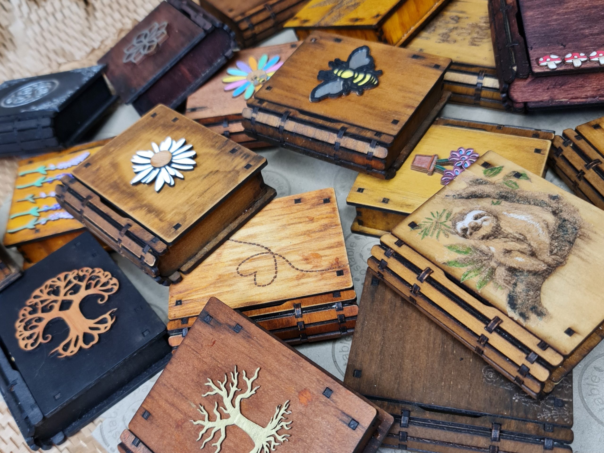 Assorted handcrafted mini wooden book boxes in a range of fantasy designs and engraved patterns.