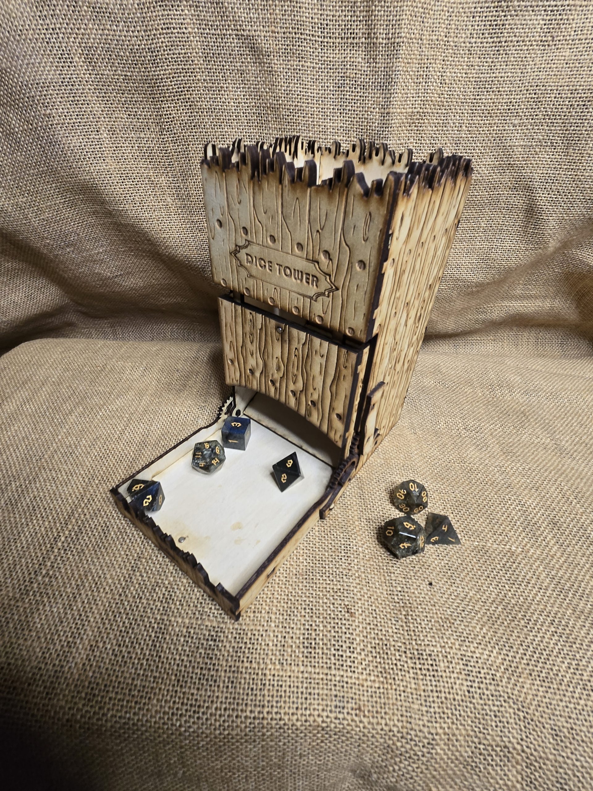 Unstained wooden dice tower with castle-style design and visible wood grain, created for tabletop dice rolling.