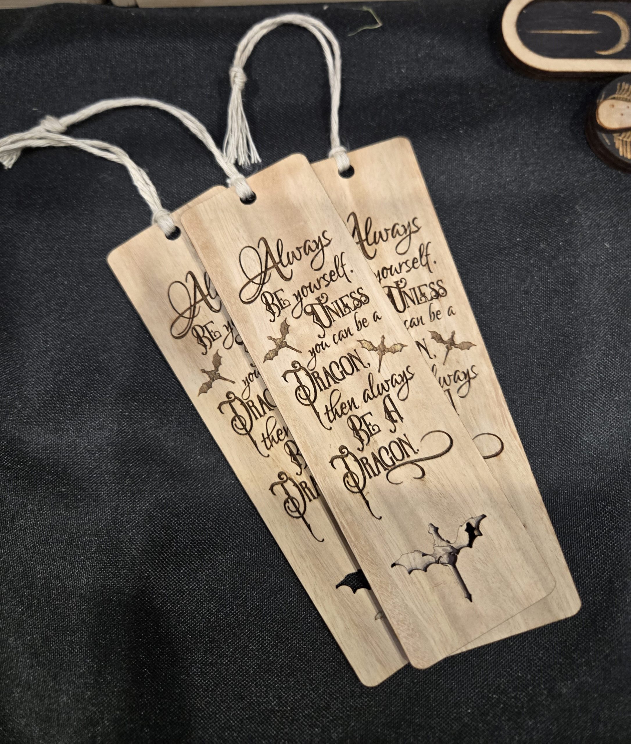 Engraved wooden bookmark made from eucalyptus and hemp, featuring a dragon-themed quote, representing fantasy decor and gift items.